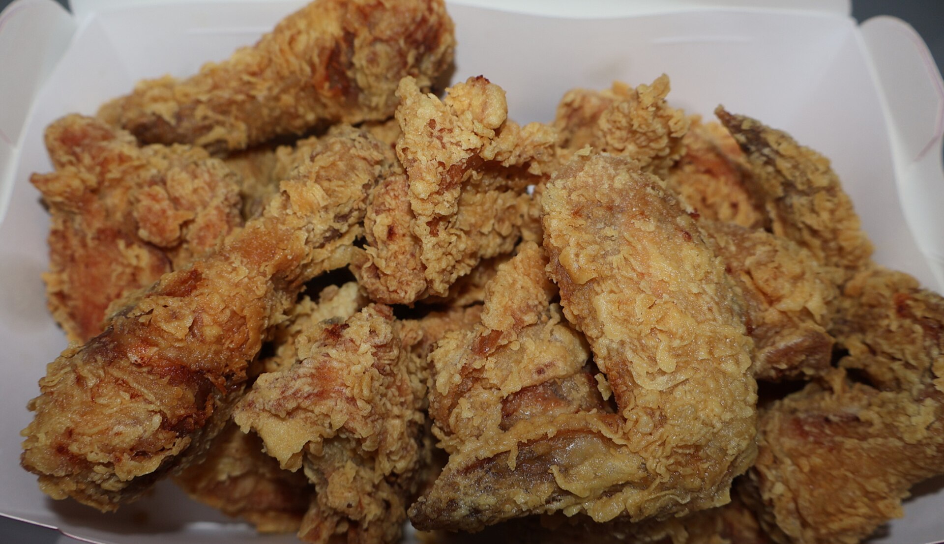 A takeaway box packed with golden fried chicken